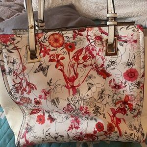 A white Michael Kors bag with flowers on it